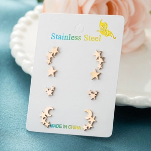 Detailed view of rose gold stainless steel star and moon earring set on display card