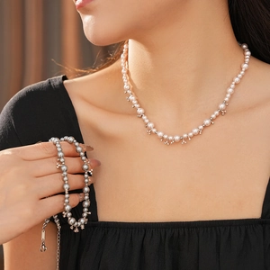 Macro view of zircon pearl beaded necklace and bracelet set on a female model