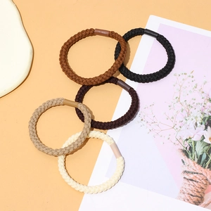 Detailed view of five woven hair ties in neutral beige, khaki, and brown shades