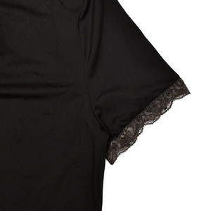 Detailed close-up of delicate black lace trim on the knit short sleeve cuff