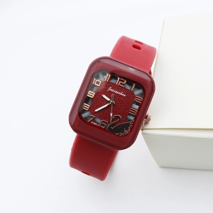 Detail of red square quartz watch with silicone strap and rose gold swan logo dial