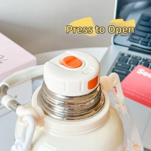 Detail of a beige insulated bottle showing a white cap with a press-to-open orange switch