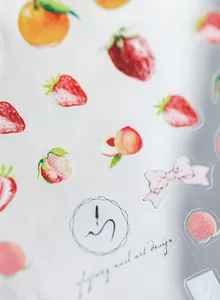 Dettaglio di adesivi nail art opachi con motivi fragola, pesca e arancione