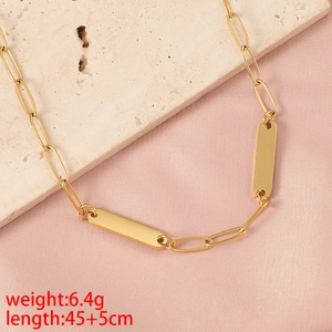Detail of gold bar necklace showing 6.4g weight and 45+5cm length on pink fabric