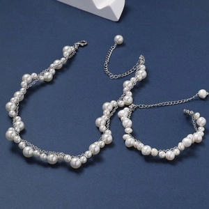 Dettaglio di collana e bracciale a due strati con perle naturali e chiusura a moschettone