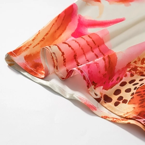 Dettaglio dell'orlo del vestito con trama in raso e stampa floreale rosa