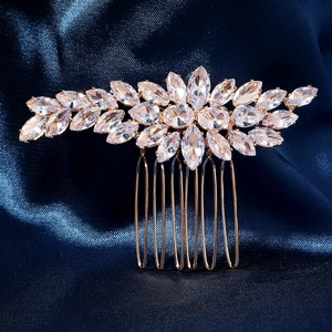 Dettaglio del pettine da sposa in oro rosa con zirconi lucidi su seta blu scuro