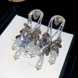 Detailed close-up of vintage gold-plated drop pearl earrings with luxury rhinestones