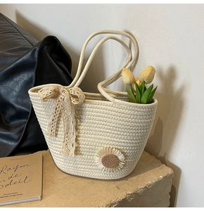 Detail of cream cotton woven tote with lace bow and sunflower floral accents