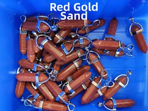 Bulk pack of hexagonal red goldstone bullet pendants with silver metal clasps in a tray