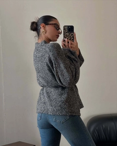 Dettaglio di un cardigan in maglia grigia da donna con vestibilità ampia e maniche lunghe