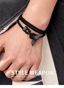 Detailed view of hand-woven black double-wrap bracelet with matte whale tail charm