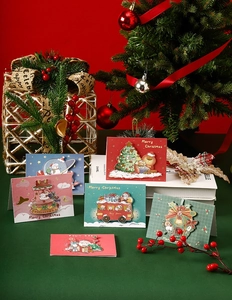 Detail shot of assorted 3D Christmas cards featuring Santa and reindeer on festive background