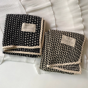 Close-up of houndstooth weave pattern on cotton scarf with Made in Korea label