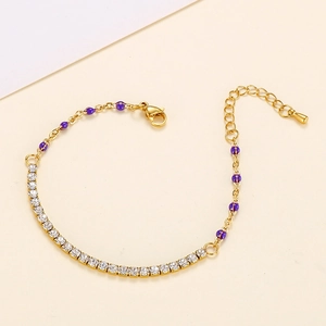 Detailed macro view of gold-plated chain bracelet with purple enamel beads and zircons