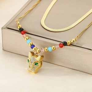Detail of gold double-layer snake chain necklace with a rhinestone leopard head pendant