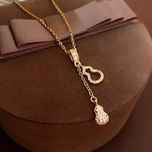 Collier luxueux à pampilles en forme de gourde dorée avec zircons sur coffret