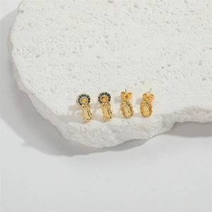 Ethnic gold Virgin Mary stud earrings set with blue crystals on white stone base