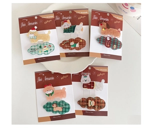 Close-up of acrylic Christmas hair clips featuring cute cartoon cats and dogs