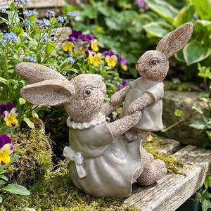 Resin bunny garden figurines showing a mother rabbit holding a baby rabbit in a floral setting