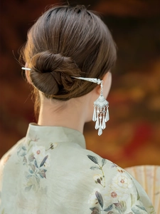 Detail of silver Hmong style hair stick with hollow patterns and flowing tassels in hair