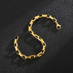 Detailed close-up of a 5mm gold-toned link box chain bracelet on a black textured surface