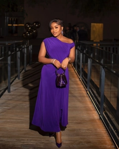 Detail of purple one-shoulder evening dress with matching handbag and high heels