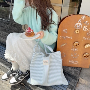 Striped mint green canvas tote bag for daily commuting shown in a high-quality lifestyle shot