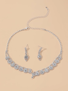 Detailed close-up of bridal jewelry set with silver floral necklace and stud earrings