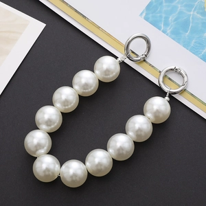 Detail of large white round pearls chain with silver metal clasps on a clean background