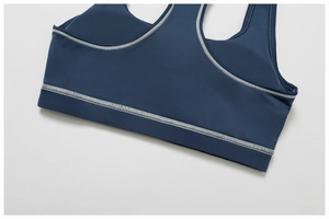 Detail of navy yoga bra featuring white contrast flatlock stitching and matte texture