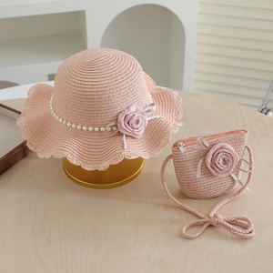 Close-up of pink woven straw hat and matching purse with fabric rose and pearl trim