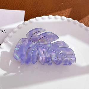 Detailed close-up of purple monstera leaf acetate hair claw with iridescent pearlescent finish
