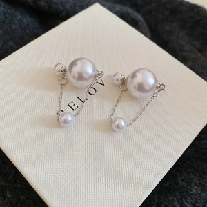 Detailed view of silver needle pearl earrings with three gradient pearls on chains