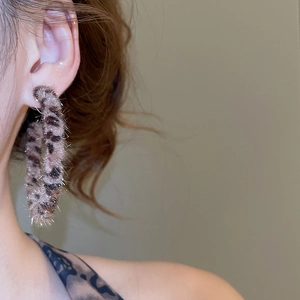 Macro shot of plush leopard print hoop earrings for women with vintage aesthetic