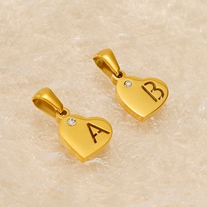 Minimalist gold heart letter A and B pendants with sparkling zircon on textured fabric