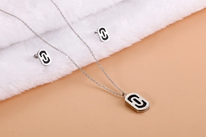 Macro view of silver paperclip jewelry set with black enamel inlay on plush surface