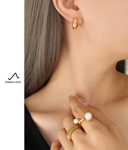 Détails de boucles d'oreilles et bagues en acier doré avec perles et design relief