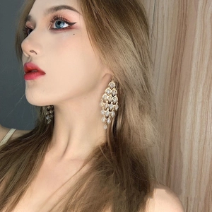 Elegant gold long tassel crystal earrings worn by model for formal wedding style