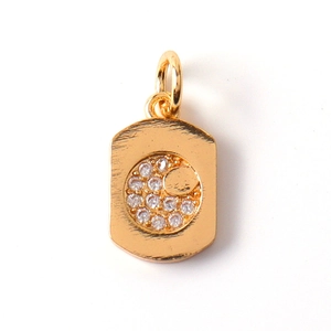 Macro shot of gold crescent moon and star rectangular charm with cubic zirconia