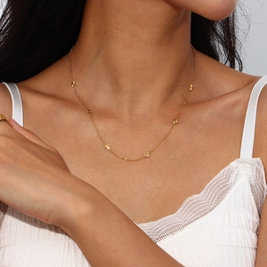 Close-up of a gold-plated stainless steel necklace with small heart charms on model