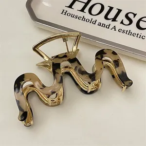 Detail showing wavy tortoiseshell finish and golden metal base of this elegant hair claw