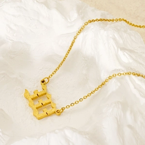 Macro shot of 1994 gold year pendant necklace with matte finish on white rock texture