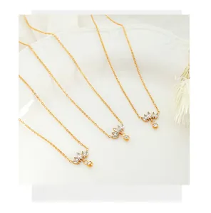 Detail of 18K gold plated necklace with fan shaped zircon pendants on white silk