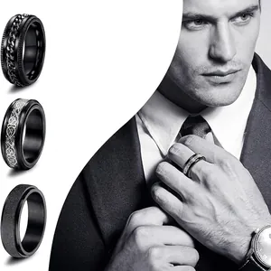 Three black stainless steel spinner rings for men featuring chain and celtic patterns