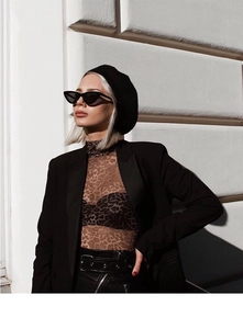 Street style view of triangular cat-eye sunglasses with trendy leopard print apparel