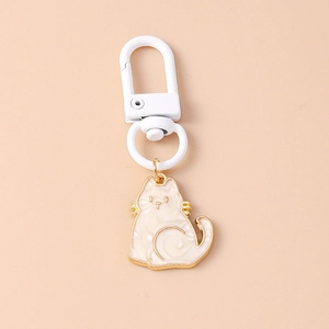 Close-up of white enamel cat pendant with golden metal frame and matching lobster clasp hook