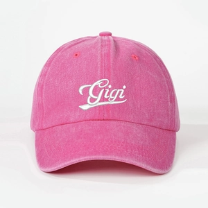 Detailed close-up of Gigi embroidery on peach pink washed denim baseball cap with air vents