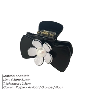 Elegant black acetate camellia hair claw clip with white flower and pearl embellishment