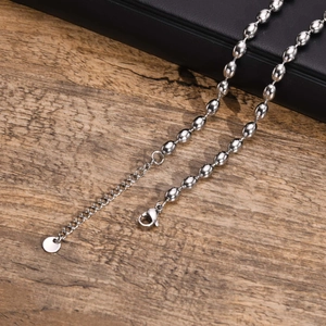 Detail of silver titanium steel oval bead necklace with a lobster clasp and extension chain